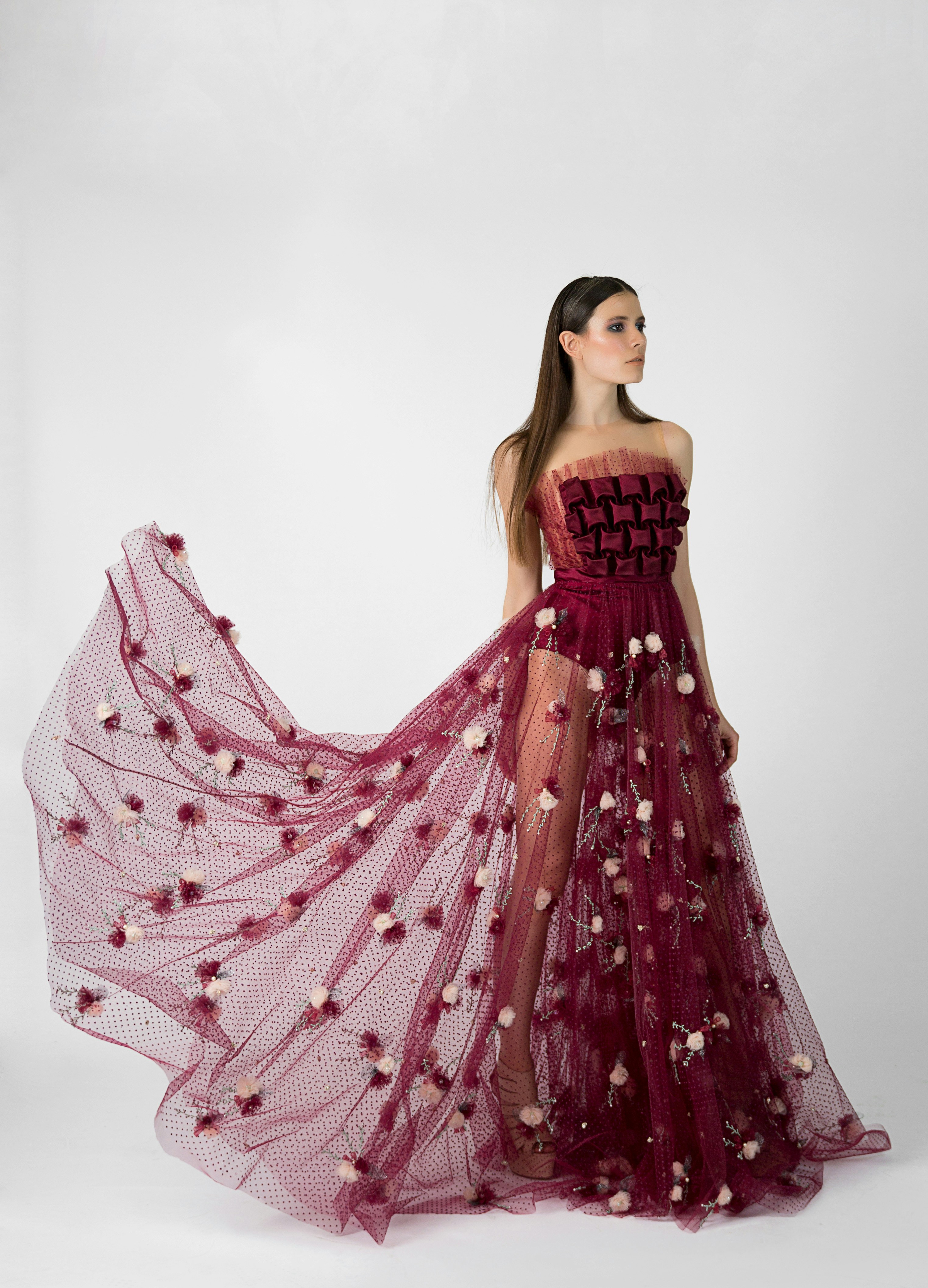 An editorial fashion model in a sculptural red dress